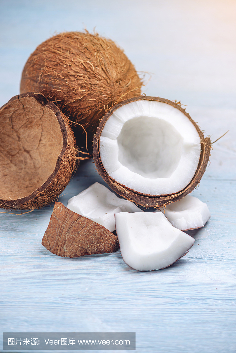 打開椰子與白色果肉在藍色木制背景。有機健康膳食產品廣泛應用于化妝品